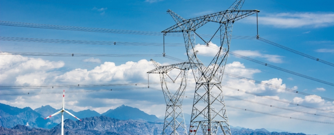 picture of electricity transmission lines and a windmill