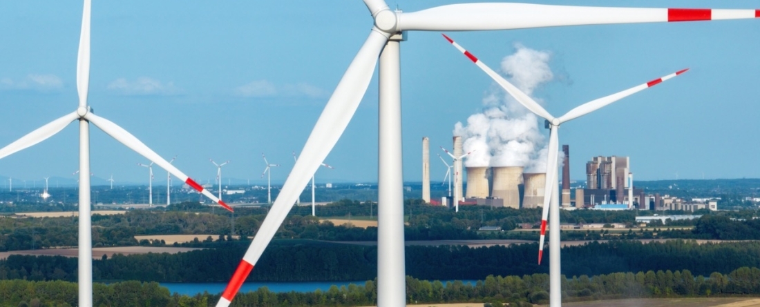 picture of windmills in front of a coal plant